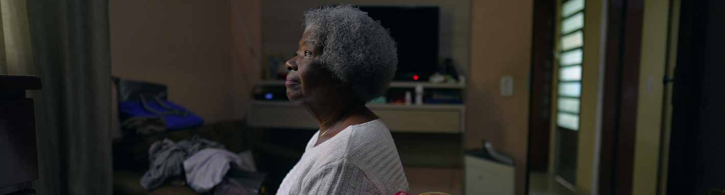 A woman sitting in a room facing off to the side.